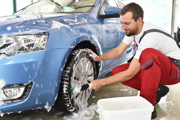 Car Wash Employee Cleaning Tires